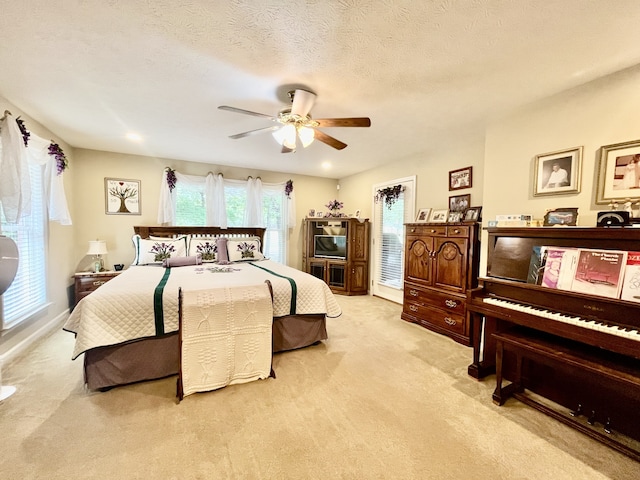 carpeted bedroom featuring a textured ceiling and ceiling fan