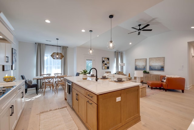 kitchen with vaulted ceiling, sink, light hardwood / wood-style floors, and a center island with sink