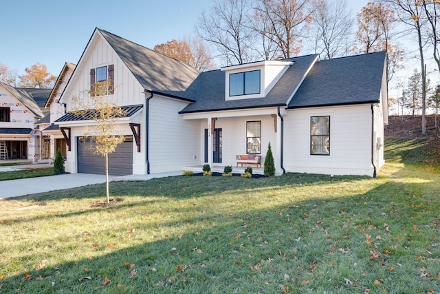 view of front of house with a garage, covered porch, and a front lawn