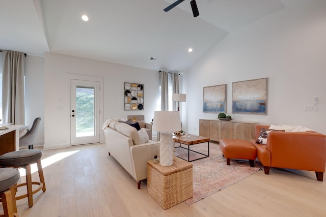 living room featuring ceiling fan, light hardwood / wood-style floors, and vaulted ceiling