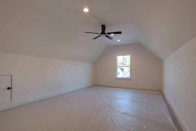 additional living space featuring ceiling fan, light carpet, and vaulted ceiling