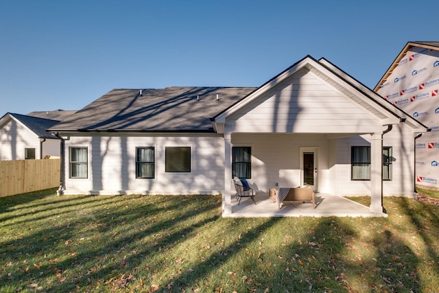 rear view of property featuring a lawn and a patio