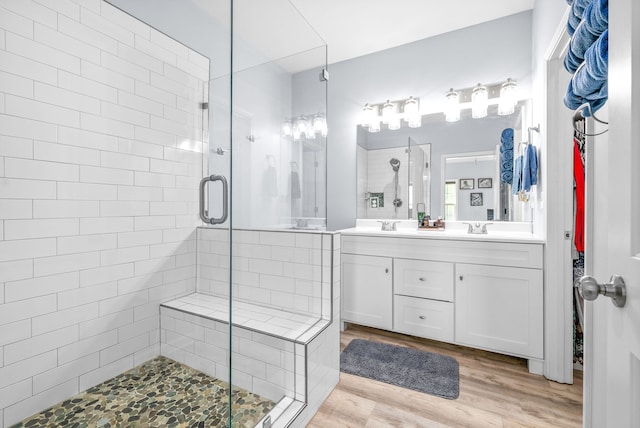 bathroom featuring vanity, a shower with shower door, and wood-type flooring