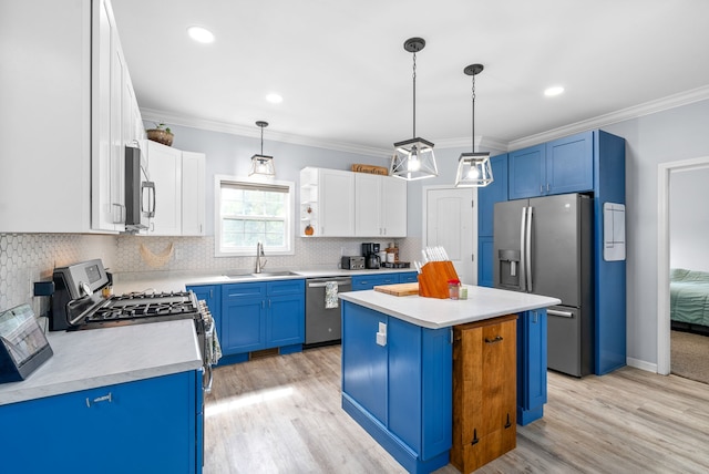 kitchen with blue cabinets, hanging light fixtures, appliances with stainless steel finishes, and a kitchen island