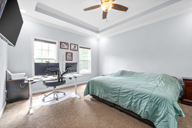 carpeted bedroom with a tray ceiling, ceiling fan, and crown molding