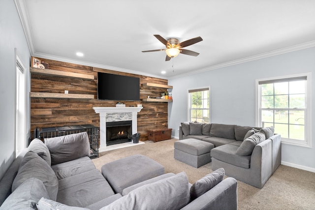 living room with ceiling fan, crown molding, and light carpet