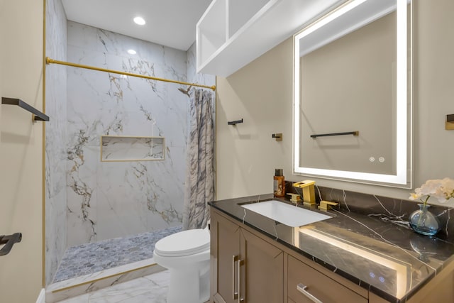 bathroom with vanity, toilet, and a tile shower