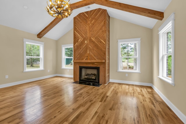 unfurnished living room with a fireplace, a healthy amount of sunlight, and lofted ceiling with beams