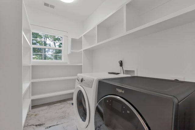 clothes washing area with separate washer and dryer