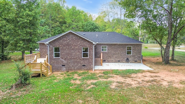 rear view of house featuring a patio area, a yard, and a wooden deck