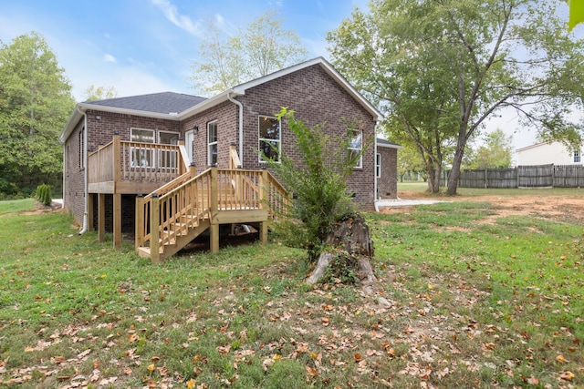 rear view of property with a yard and a deck