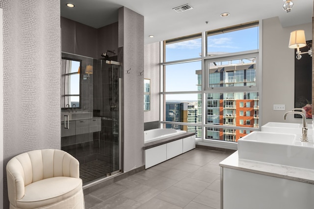 bathroom featuring vanity, independent shower and bath, and tile patterned floors