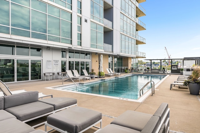 view of swimming pool featuring an outdoor living space and a patio area