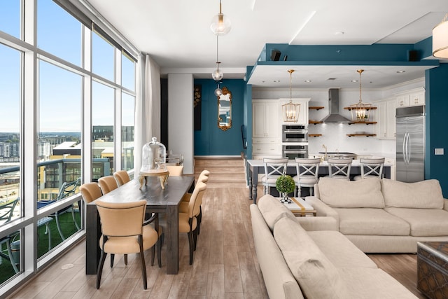 interior space with light wood-type flooring, expansive windows, and an inviting chandelier