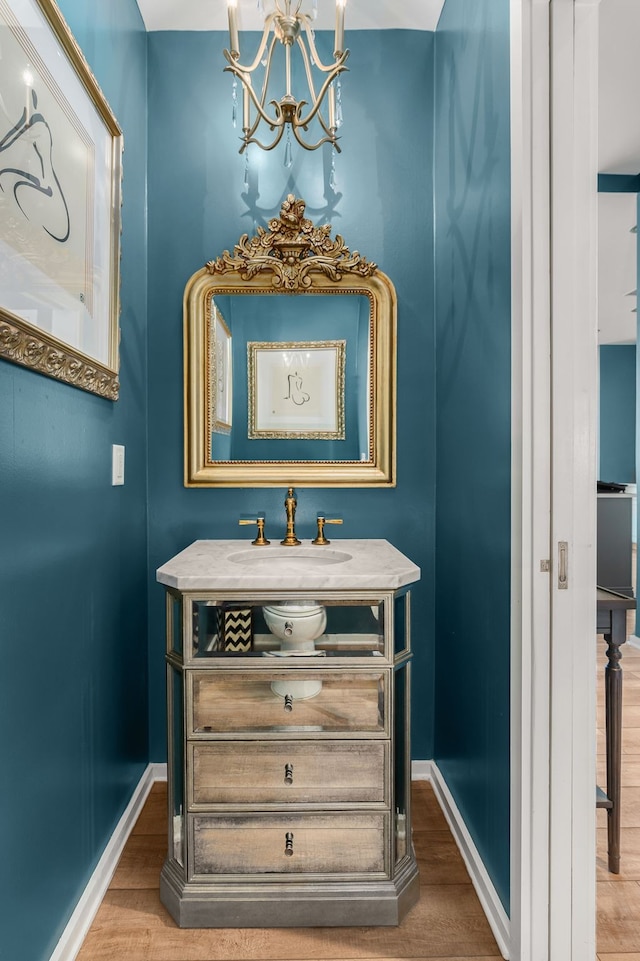 bathroom with vanity, hardwood / wood-style flooring, and a notable chandelier