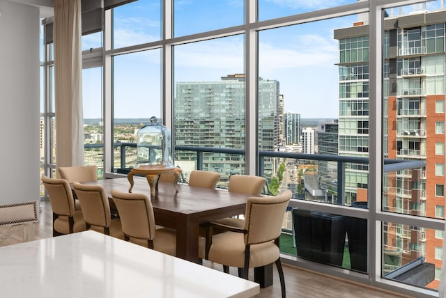 dining room featuring a wall of windows and hardwood / wood-style flooring