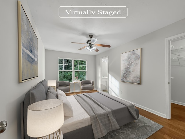 bedroom with a closet, ceiling fan, hardwood / wood-style floors, and a spacious closet