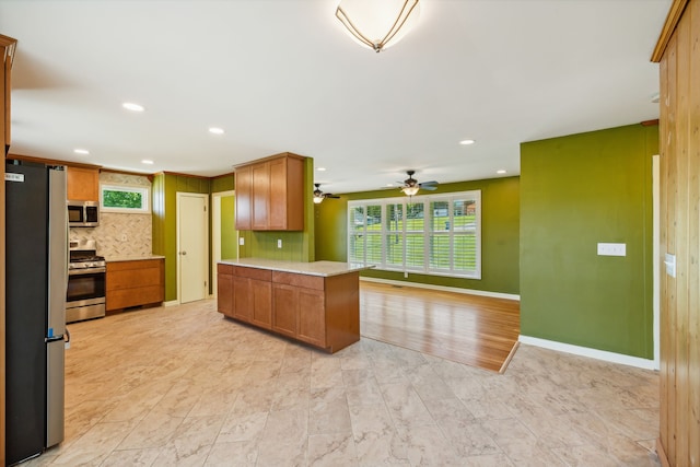 kitchen featuring appliances with stainless steel finishes, backsplash, and ceiling fan