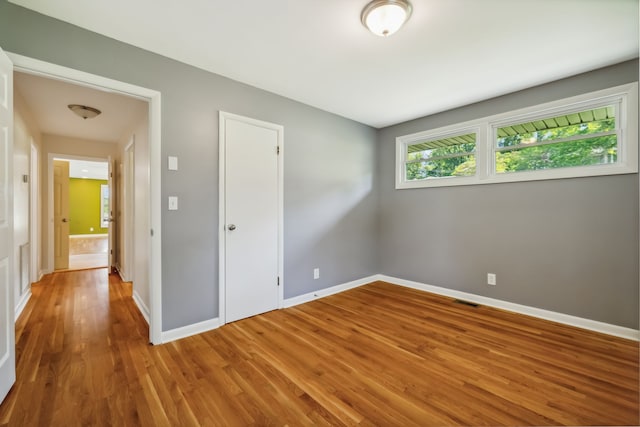 unfurnished room with wood-type flooring