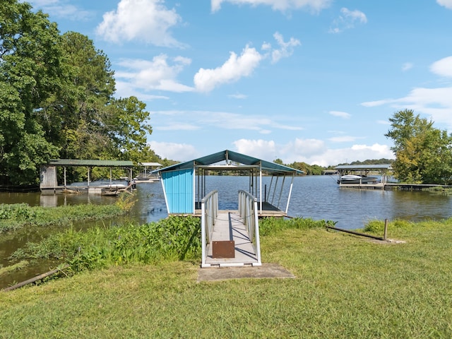 view of dock with a lawn and a water view