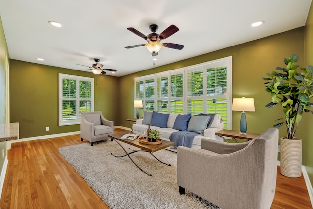 living room with light hardwood / wood-style flooring and ceiling fan