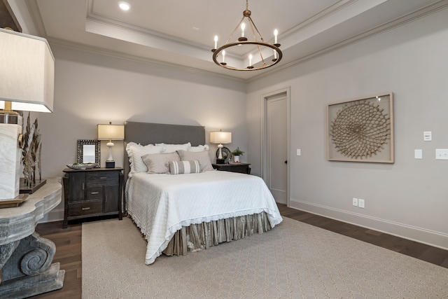 bedroom with ornamental molding, a raised ceiling, dark hardwood / wood-style flooring, and an inviting chandelier