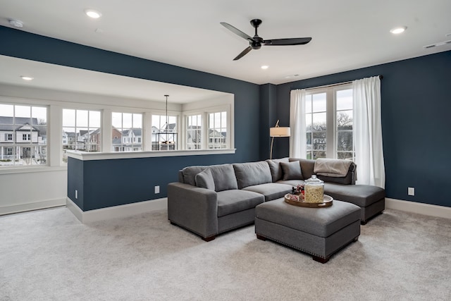 living room with ceiling fan, a wealth of natural light, and light carpet