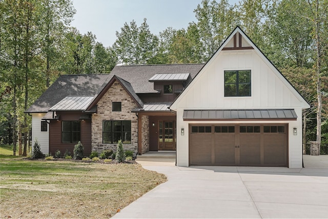 modern inspired farmhouse featuring a front yard and a garage