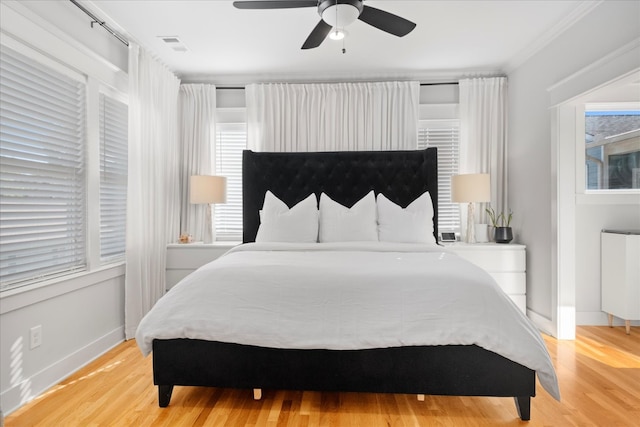 bedroom with ornamental molding, light wood-type flooring, ceiling fan, and radiator