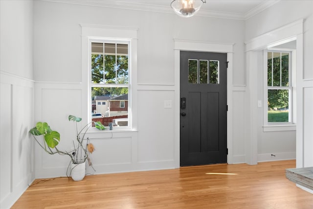 entryway featuring crown molding, hardwood / wood-style floors, and a healthy amount of sunlight