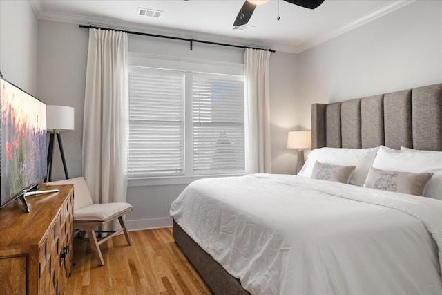 bedroom with light hardwood / wood-style flooring, ceiling fan, and ornamental molding