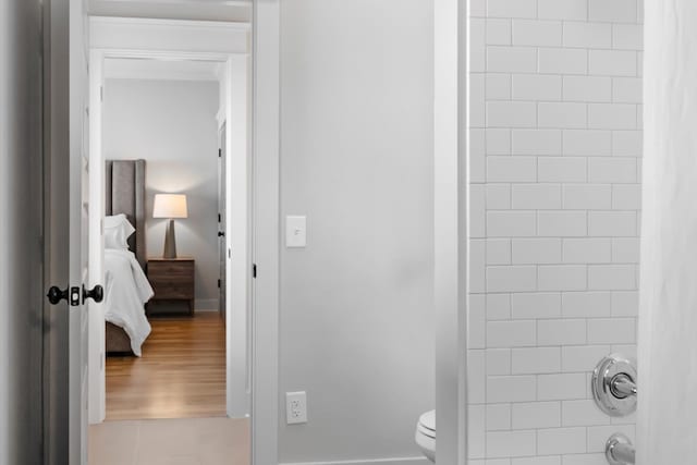 bathroom with walk in shower, hardwood / wood-style floors, and toilet