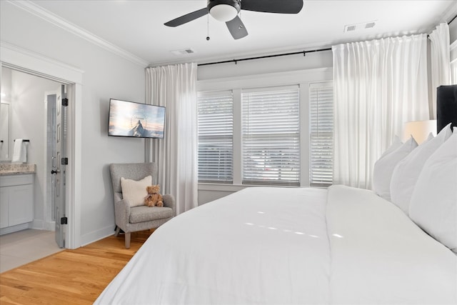 bedroom with crown molding, connected bathroom, hardwood / wood-style floors, and ceiling fan