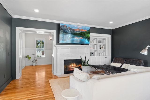 living room featuring ornamental molding, a brick fireplace, and hardwood / wood-style flooring