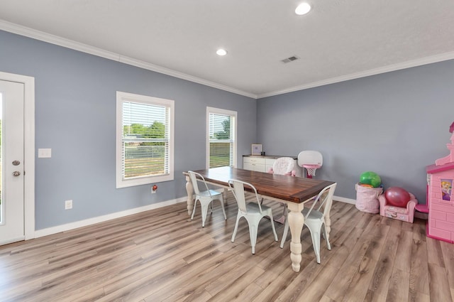 dining space with light wood-type flooring, baseboards, visible vents, and ornamental molding