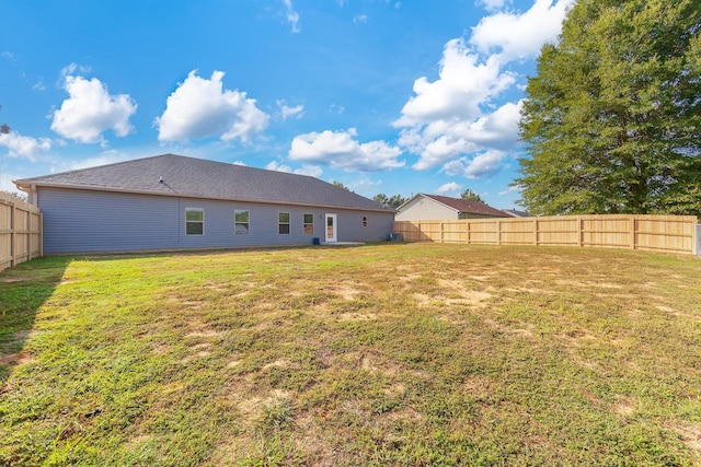 back of house featuring a lawn and a fenced backyard