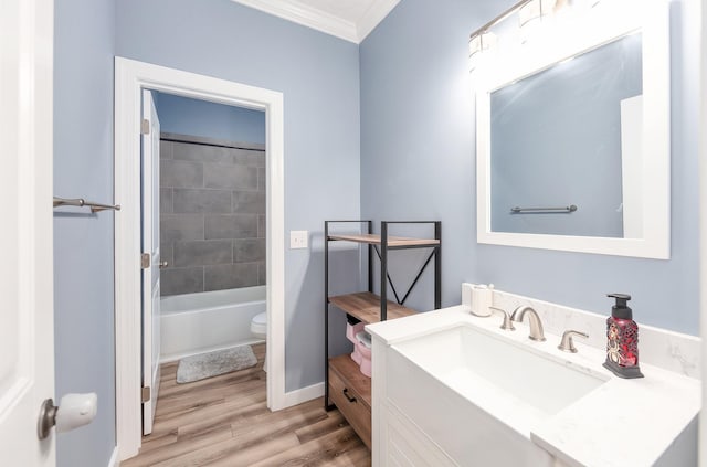 full bath featuring crown molding, baseboards, toilet, wood finished floors, and vanity