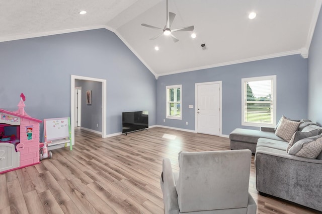 living area with visible vents, baseboards, ornamental molding, light wood-style flooring, and a ceiling fan