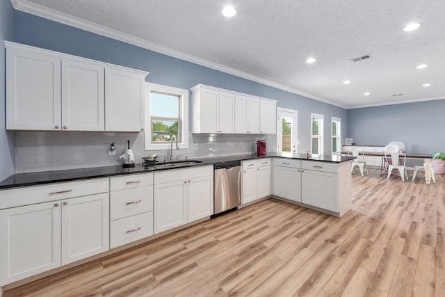 kitchen with visible vents, a sink, tasteful backsplash, stainless steel dishwasher, and light wood-style floors