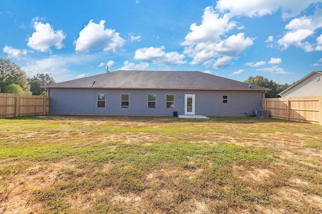 rear view of property with a yard and a fenced backyard