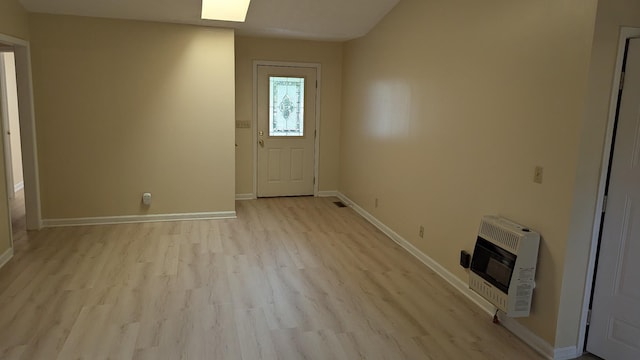 foyer with visible vents, heating unit, baseboards, and light wood-type flooring