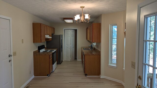 kitchen with electric stove, light hardwood / wood-style floors, a textured ceiling, and sink