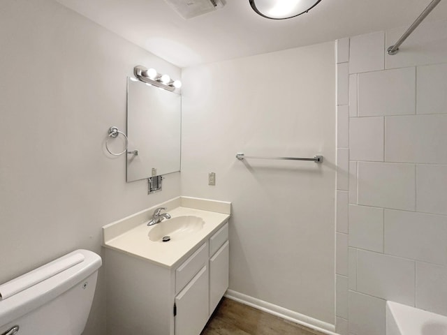 bathroom featuring baseboards, toilet, and vanity