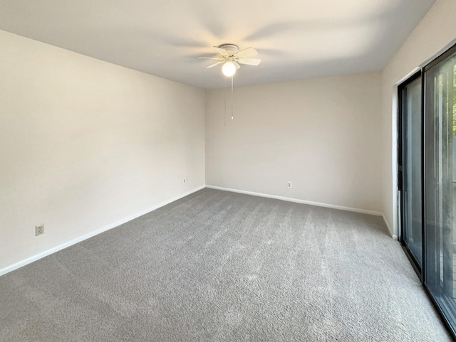 unfurnished room featuring a ceiling fan, baseboards, and dark carpet