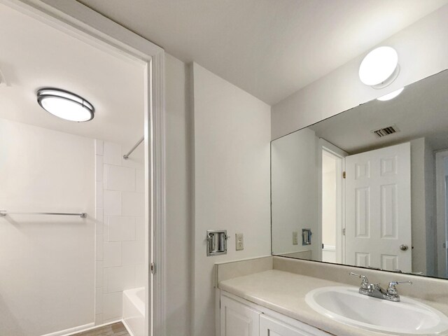 bathroom with vanity, wood-type flooring, and shower / bathtub combination