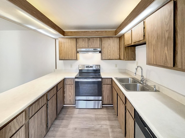 kitchen with under cabinet range hood, stainless steel appliances, light countertops, and a sink