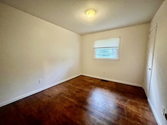 spare room with dark hardwood / wood-style flooring