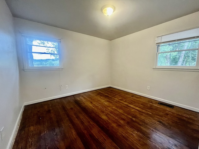 spare room with dark wood-type flooring