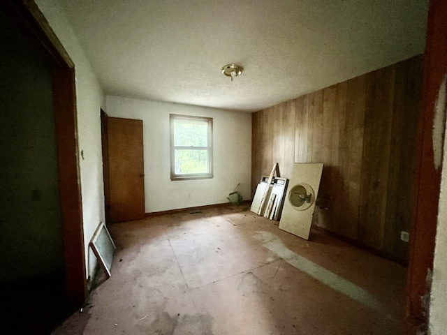 miscellaneous room with a textured ceiling and wood walls