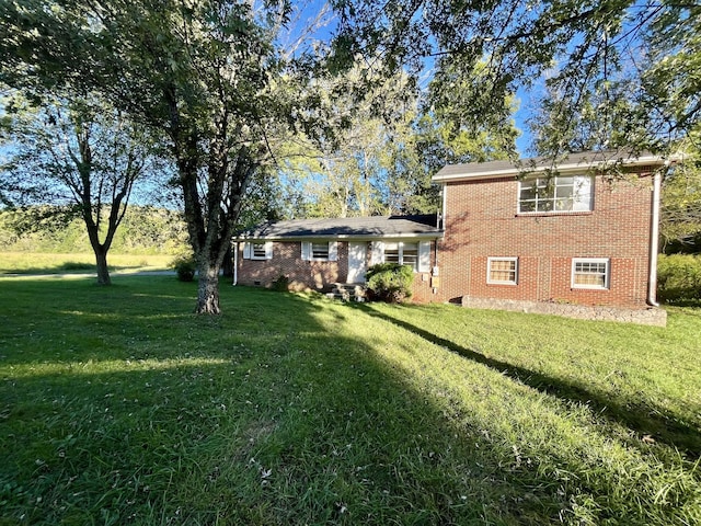 view of front of house with a front yard and brick siding